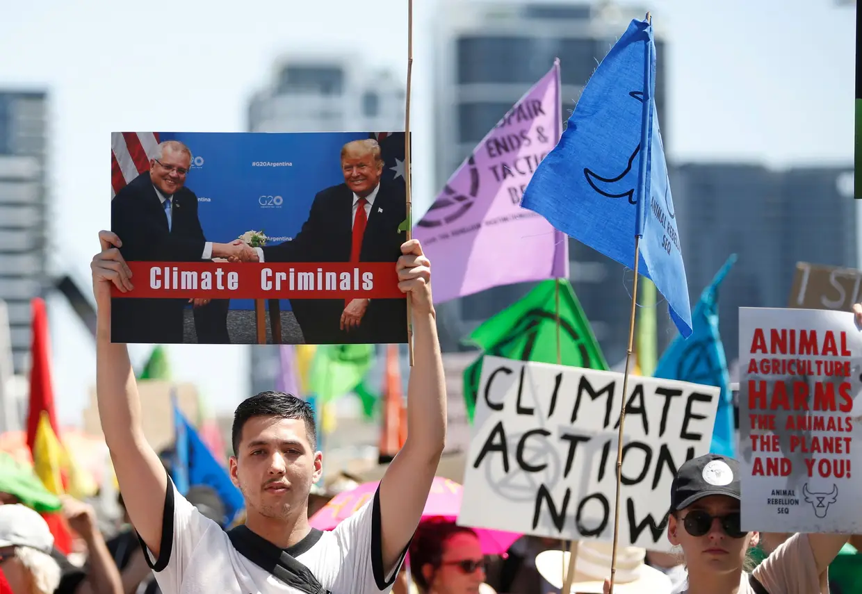 Manifestação em em Brisbane, Queensland, Austrália , 07 de outubro de 2019. Na faixa lê-se "criminosos do Clima" representando o Presidente dos EUA Trumpe o Primeiro Ministro Australiano Morrison apertando.