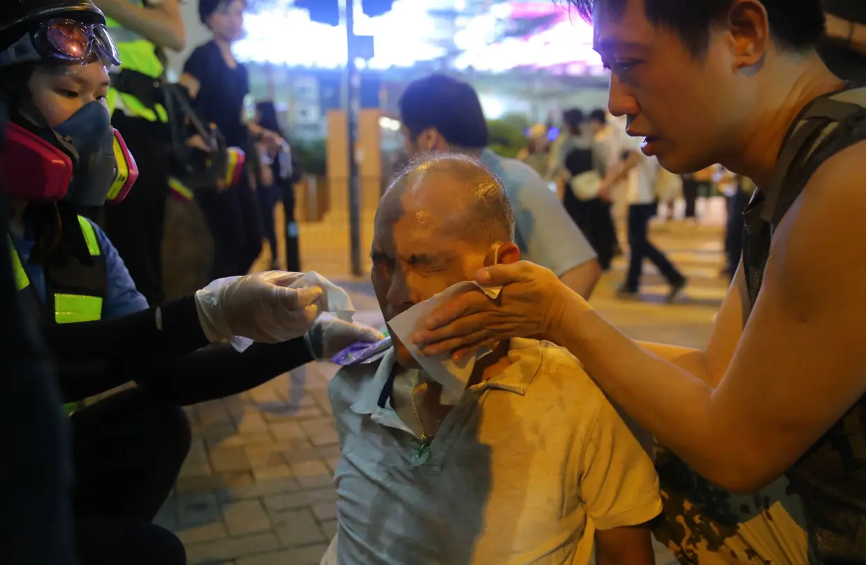 Manifestante atingido por gás lacrimogéneo nos protestos em Hong Kong, China.