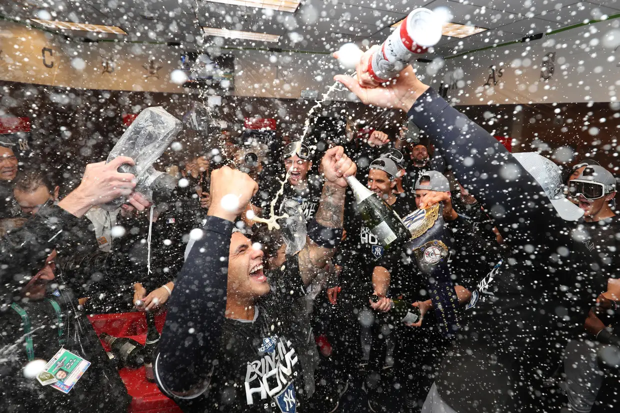 Jogadores do New York Yankees celebram a passagem à final da Liga Americana de basebol no balneário.