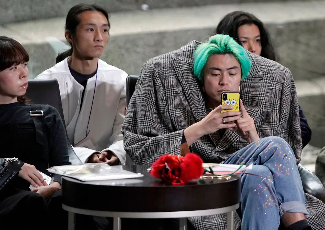 Um jovem assiste à Semana da Moda de Tóquio, no Japão.