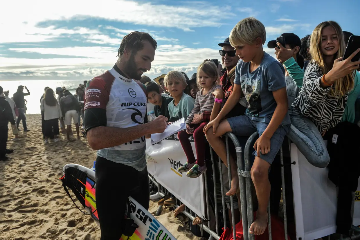 O surfista português Frederico Morais dá um autógrafo a uma criança no MEO Rip Curl Pro Portugal 2019, Praia dos Supertubos, Peniche.