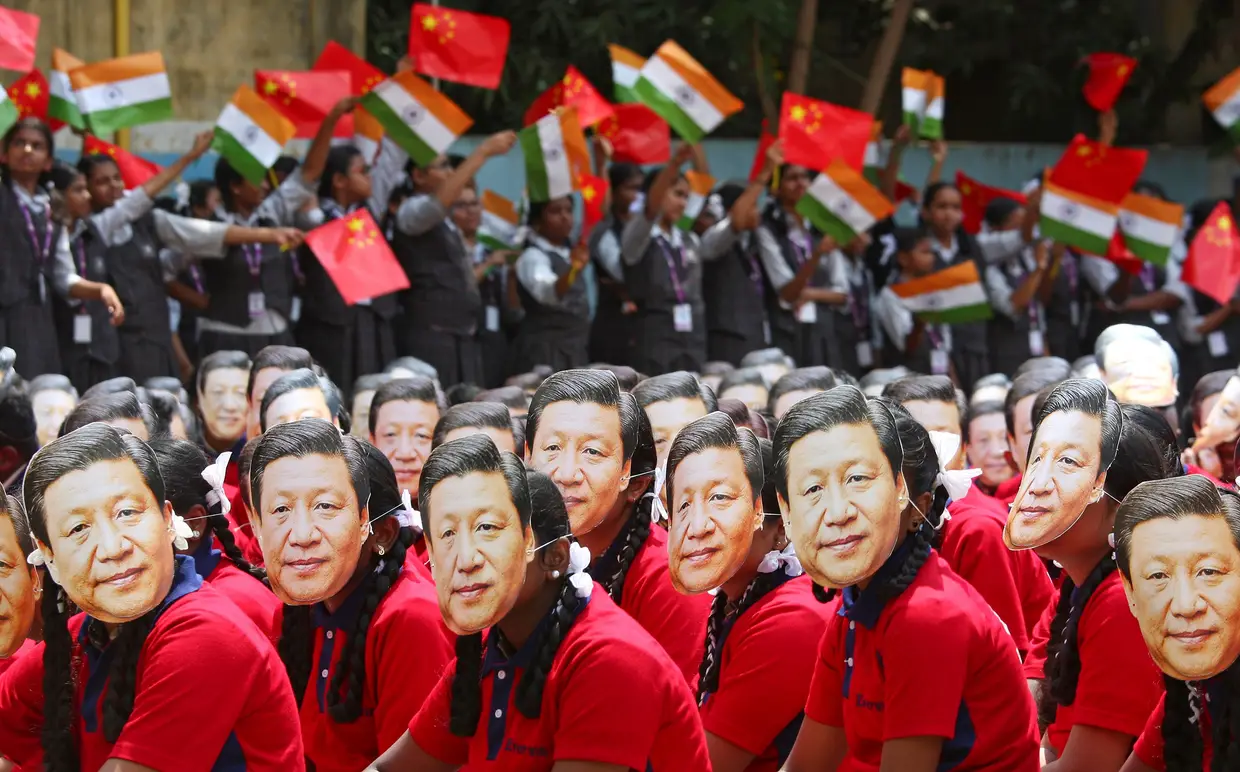 Estudantes com máscaras do Presidente Xi Jinping, numa visita do Presidente chinês à Índia.