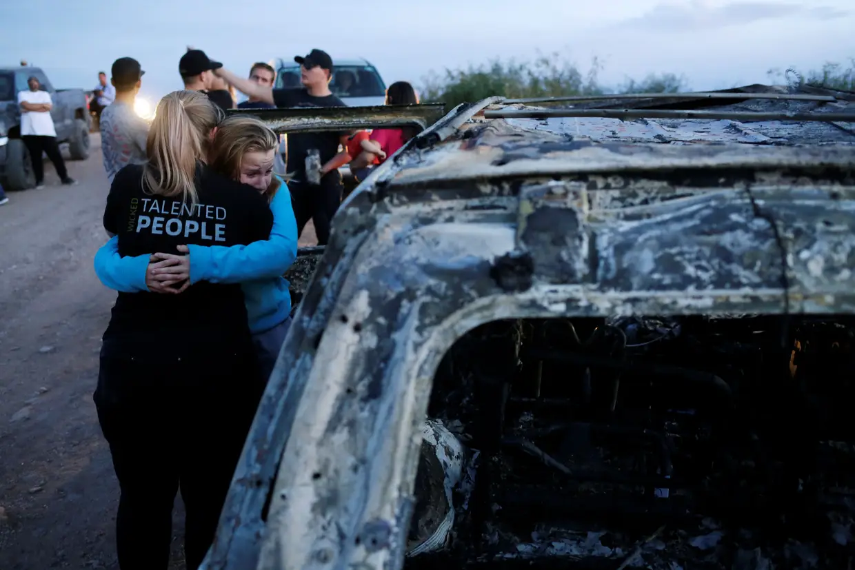 Parentes de famílias mexicanas ao lado dos destroços de um carro em que alguns morrem, em Sonora, no México