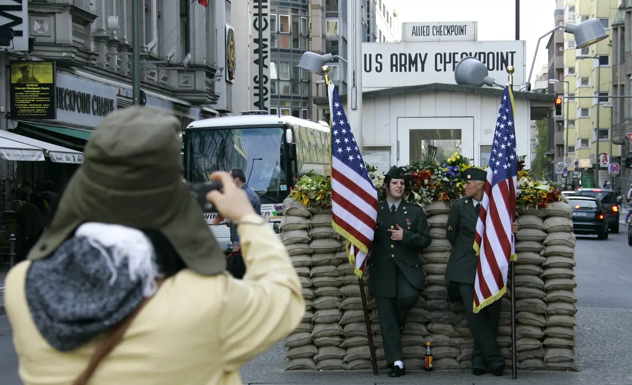 Um turista tira foto no antigo posto de controlo aliado Charlie, em Berlim, onde guardas de fronteira da Alemanha Oriental fiscalizavam membros das forças aliadas americanas, desencadeando confrontos entre as forças norte-americanas e do Exército Vermelho, que chegaram a confrontar-se 16 horas consecutivas há 45 anos atrás.