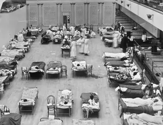 Fotografia de 1918 disponibilizada pela Biblioteca do Congresso dos EUA mostra enfermeiras da Cruz Vermelha Americana a vacinar pacientes no Auditório Municipal de Oakland, usado como hospital temporário durante a pandemia de gripe de 1918-1919