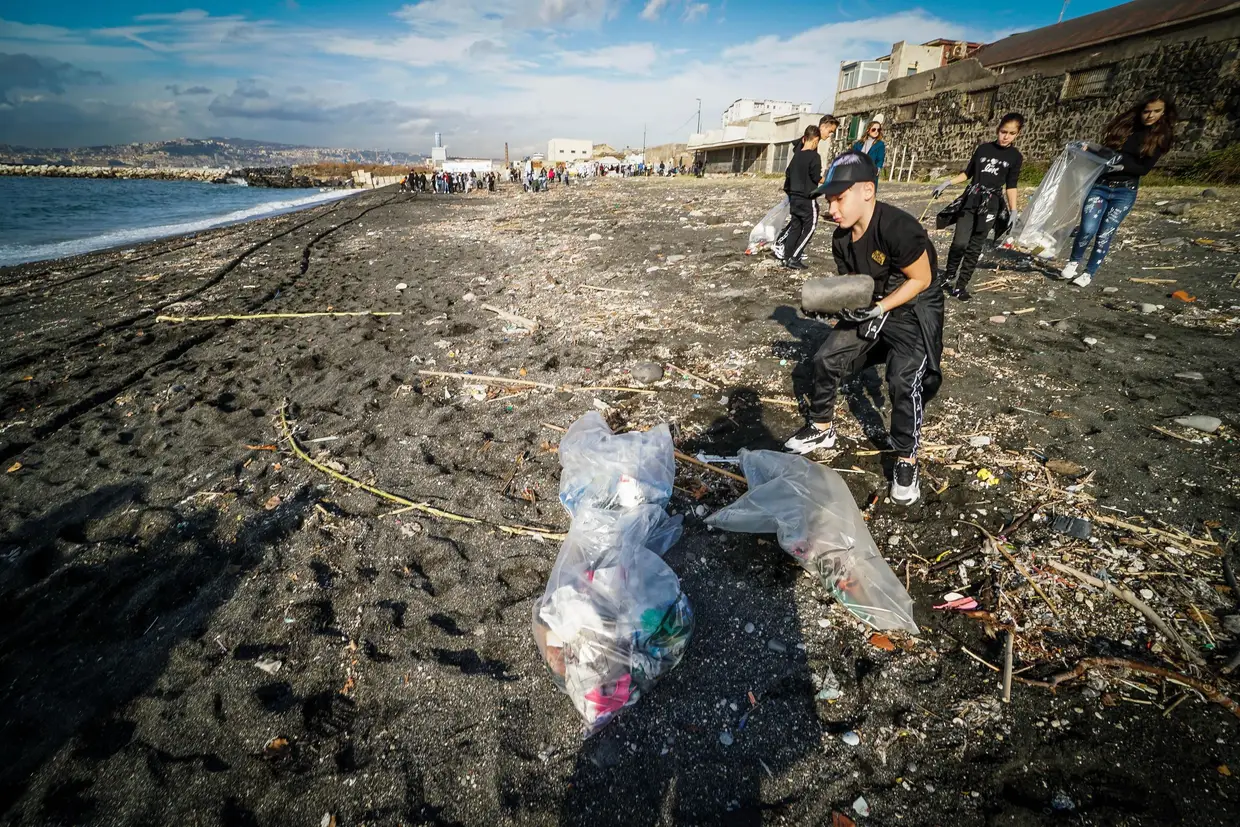 Voluntários limpam o lixo de uma praia em San Giovanni a Teduccio, perto de Nápoles, em Itália.