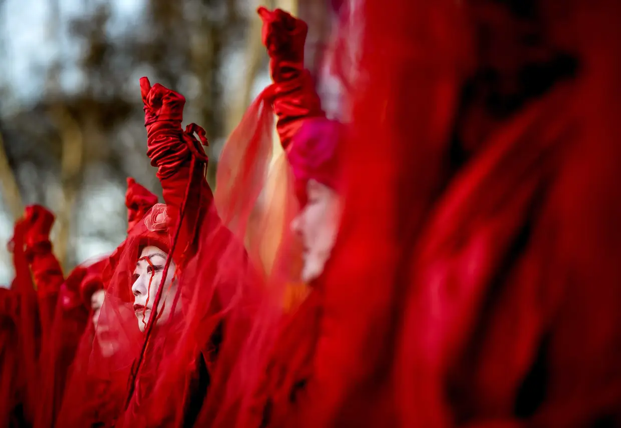 Manifestantes dos movimentos "Extinction Rebellion" e "Red Rebels" durante uma marcha pelo clima até à embaixada australiana em Haia, na Holanda.