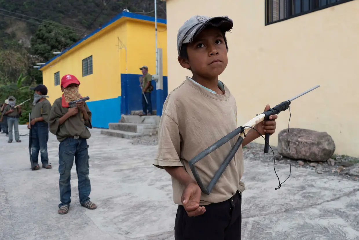 Crianças mostram a um jornalista da Reuters as novas técnicas com armas de brincar que aprenderam num treino em Ayahualtempa, no México.