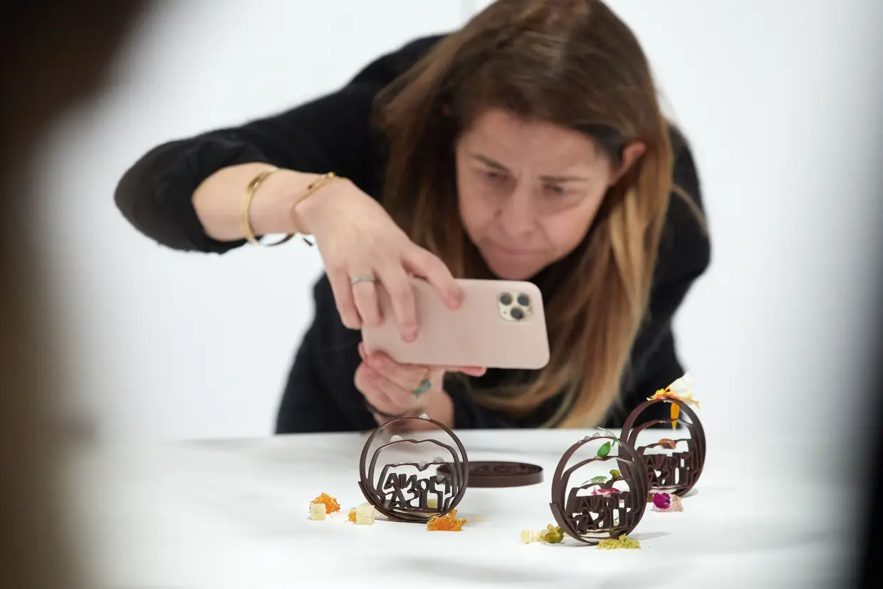 Uma mulher fotografa várias esculturas de chocolate imprimidas pela primeira impressora 3D industrial de chocolate, em Girona, Espanha.