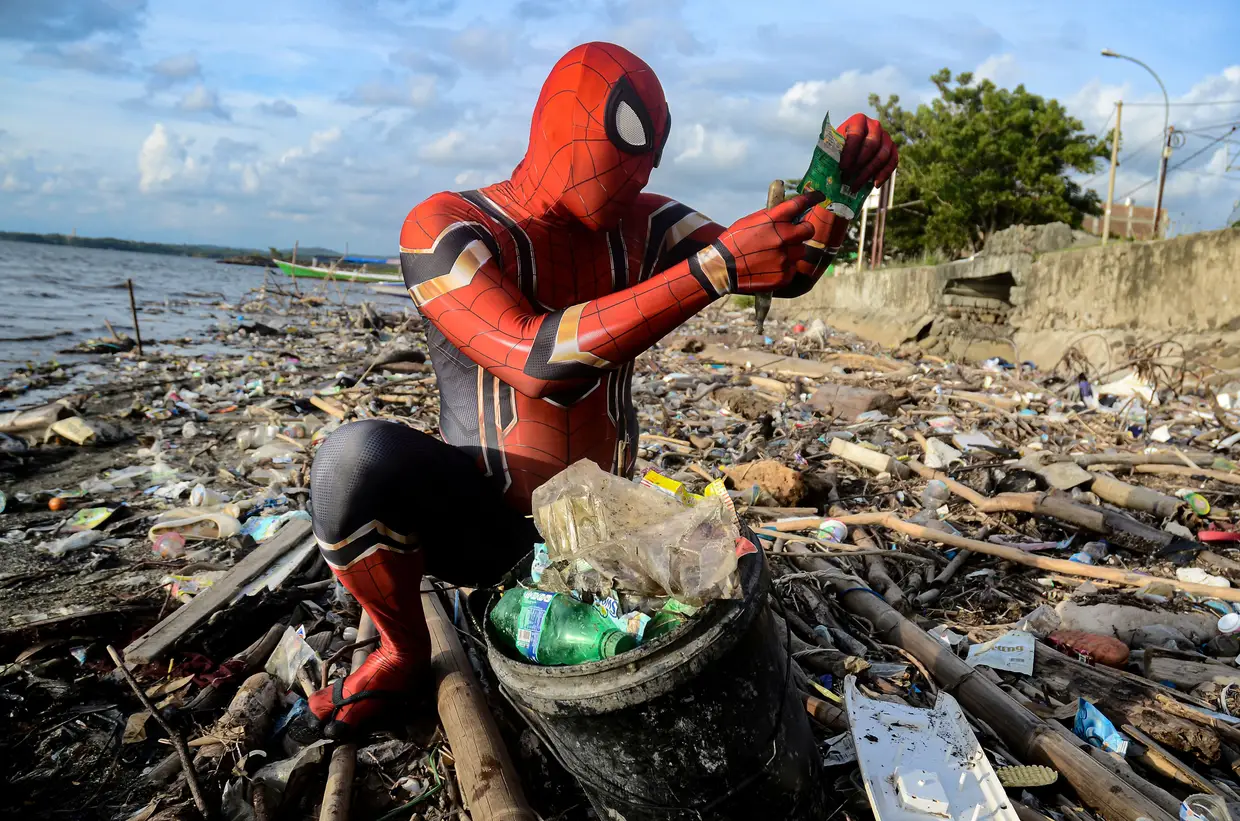 Um Homem-Aranha procura por plástico na praia de Pare-Pare, Celebes do Sul, Indonésia.