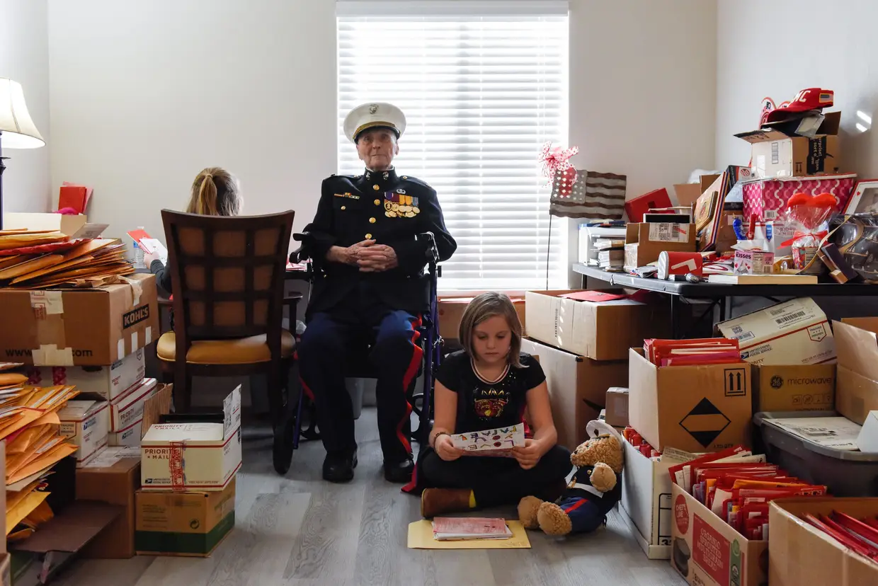 O major Bill White, um veterano de guerra com 104 anos, senta-se com as netas entre milhares de cartas do Dia dos Namorados, Stockton, Califórnia, EUA.
