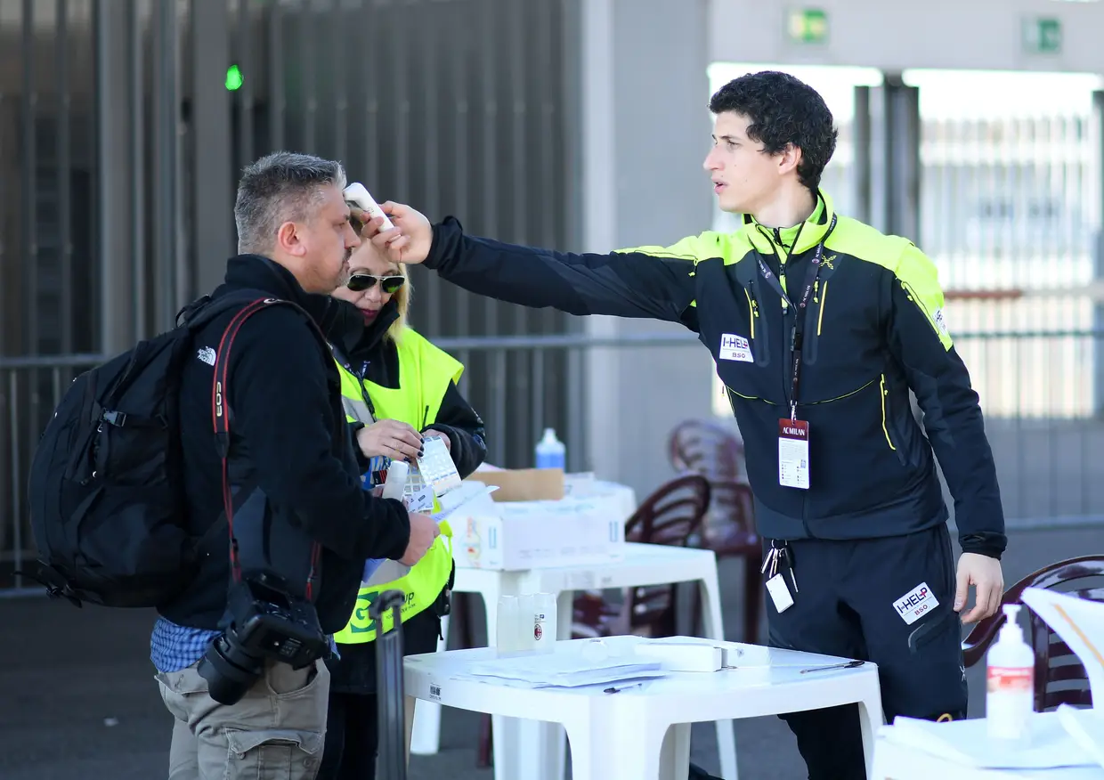 Jornalista passa pelo controlo de medição da temperatura corporal à entrada do Estádio de San Siro, antes do jogo entre o AC Milan e o Génova.