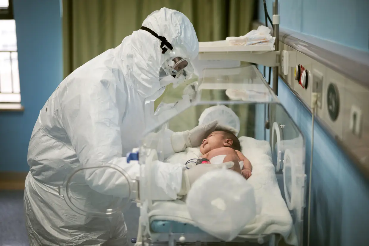 Um profissional de saúde trata de um bebé infetado com o novo coronavírus num hospital pediátrico em Wuhan, na China.