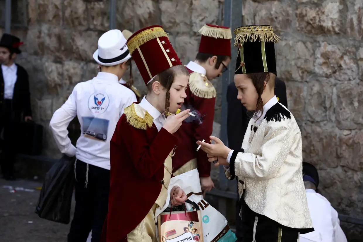 Crianças fumam durante as celebrações do feriado judeu Purim, em Mea Shearim, Jerusalém.