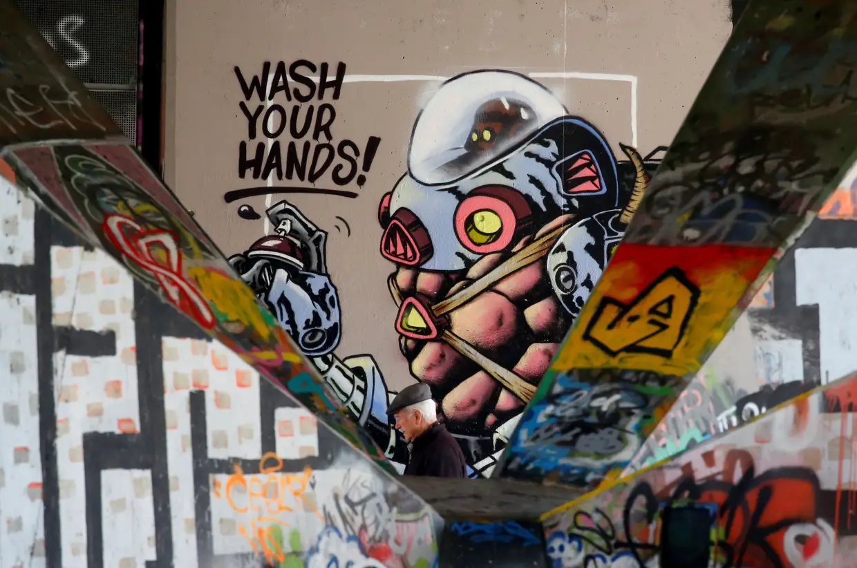 Um graffiti onde se pode ler "Lave as mãos" numa parede em Viena, na Áustria.