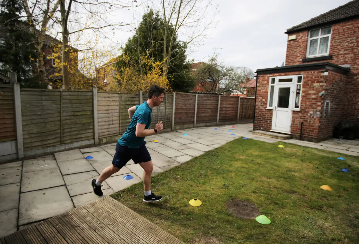 Nick Lowden corre uma maratona no jardim para angariar dinheiro para o Serviço Nacional de Saúde britânico, em Manchester, Reino Unido