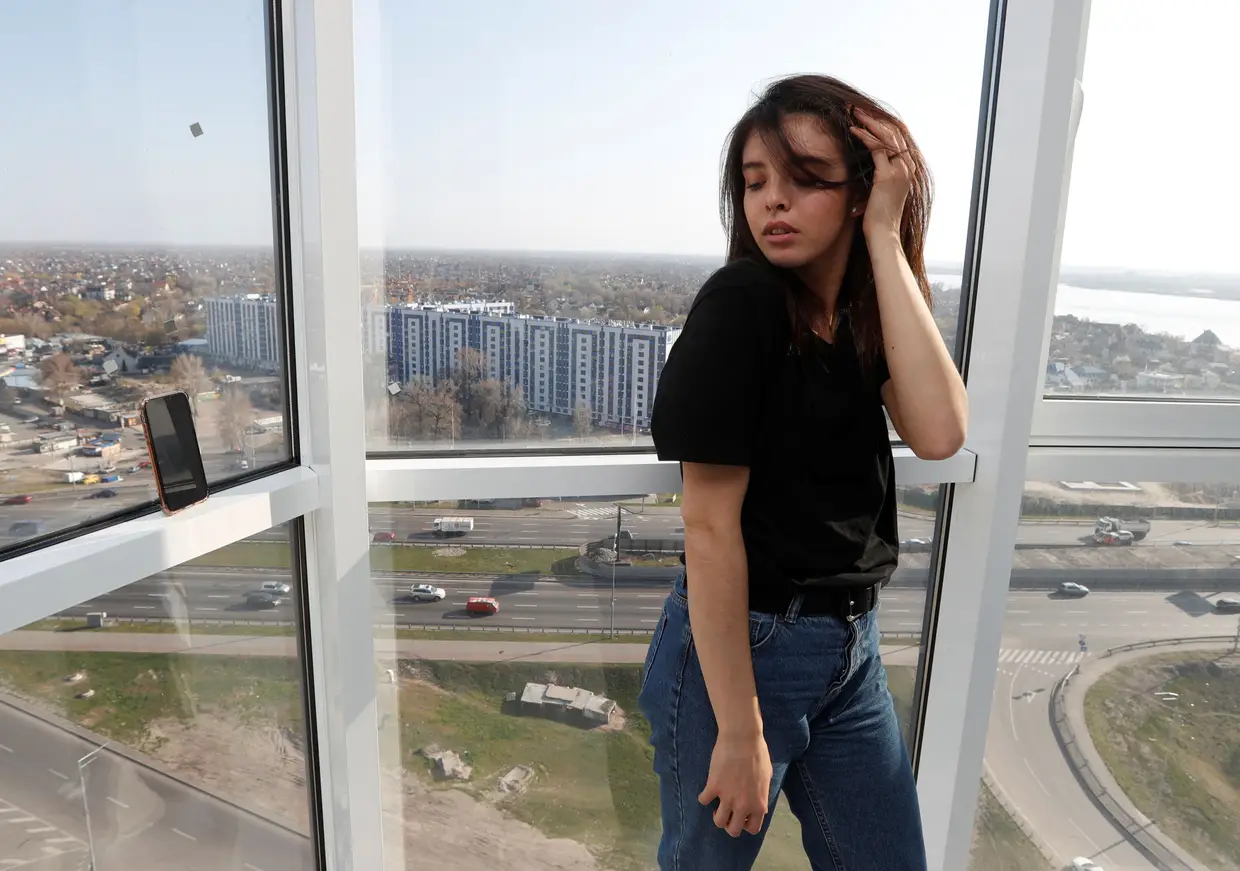 A bailarina Alina Kobyliak posa para uma fotógrafa ucraniana, que utiliza o smartphone para tirar fotos como capturas de ecrã por videochamada, em Kiev, Ucrânia