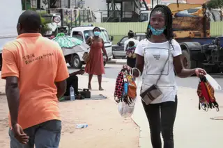 Uma vendedora de rua vende máscaras reutilizáveis feitas à mão em Luanda, Angola