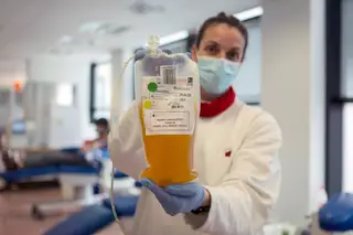 Enfermeira de hospital em Barcelona mostra o plasma doado para um ensaio clínico em Espanha.