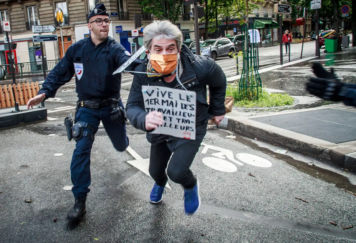 Autoridades tentam deter um manifestantes durante um protesto que marca o Dia do Trabalhador, Paris, França.