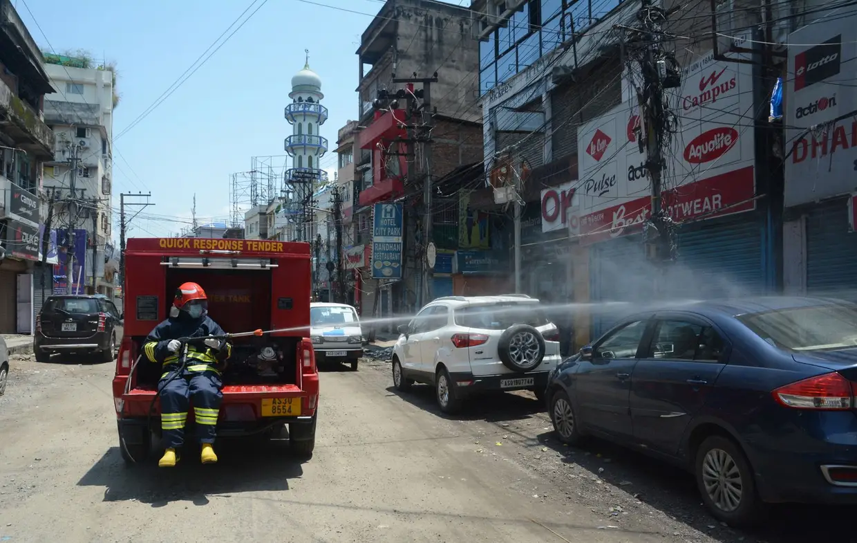 Um bombeiro desinfeta uma rua de Guwahati, na Índia, durante o confinamento do país, face à pandemia do novo coronavírus.