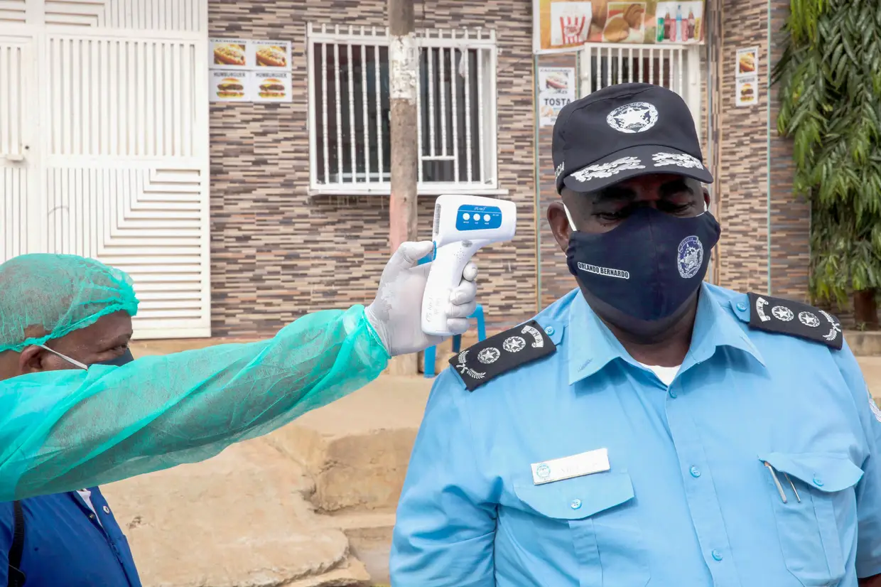 Um polícia faz rastreio da temperatura corporal no âmbito da covid-19, durante a inauguração do Centro Eletrónico de Seguraça Pública (CESP) da Polícia Nacional de Angola, Luanda.