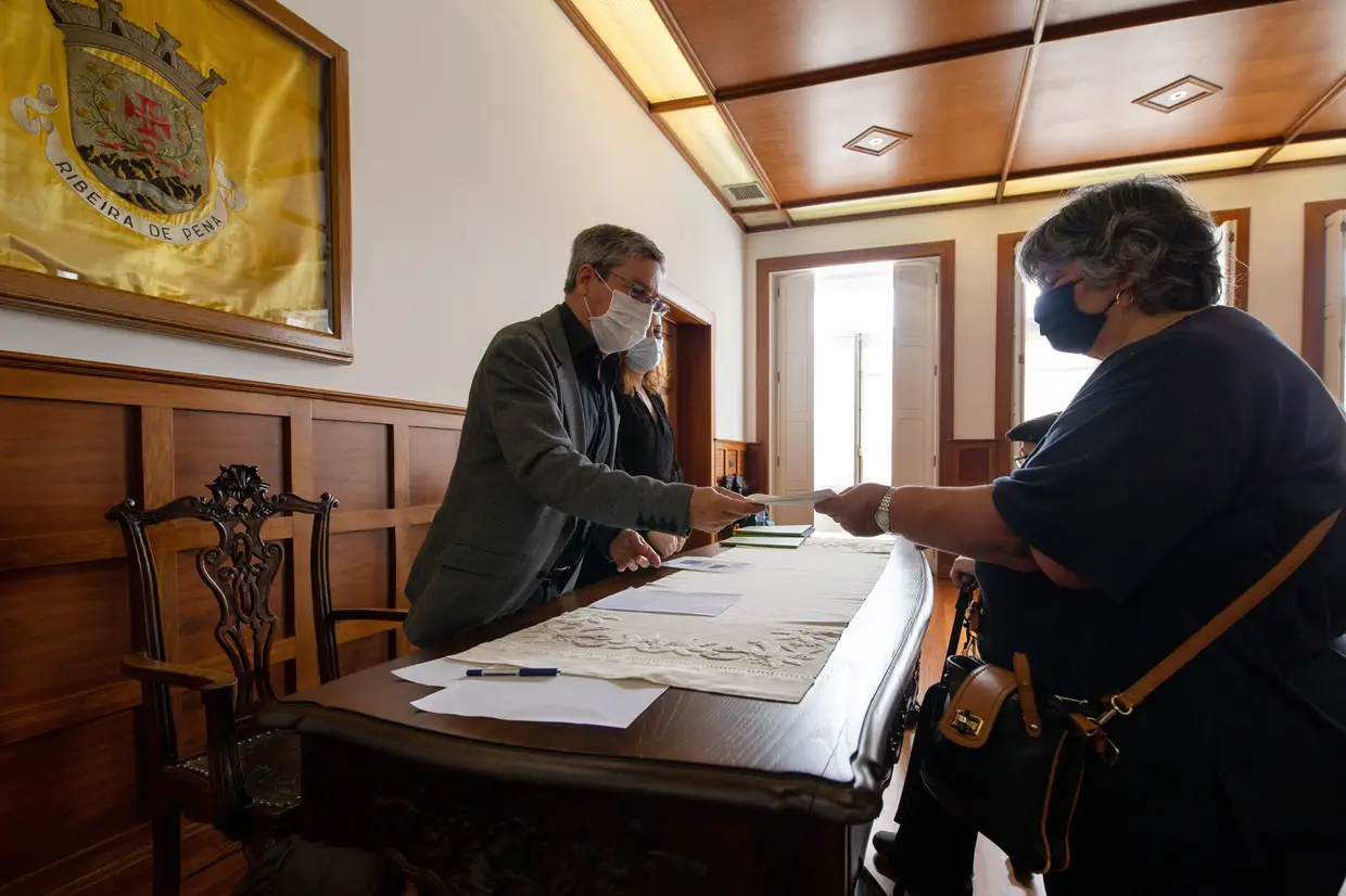 O presidente da Câmara Municipal de Ribeira de Pena, João Noronha, ladeado pela representante da empresa Iberdrola, Sara Soya, faz a entrega de um cheque de compensação pelas habitações destruídas pelas barragens, em Ribeira de Pena