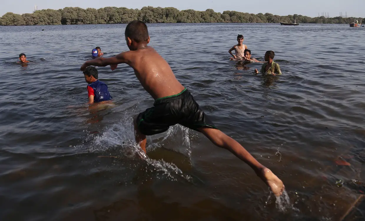 Rapaz paquistanês a mergulhar no Mar Arábico para combater o calor que se sente na província de Sindh, no Paquistão.
