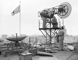 Engenheiros do laboratório da companhia Bell Telephone, durante a manutenção de uma antena.