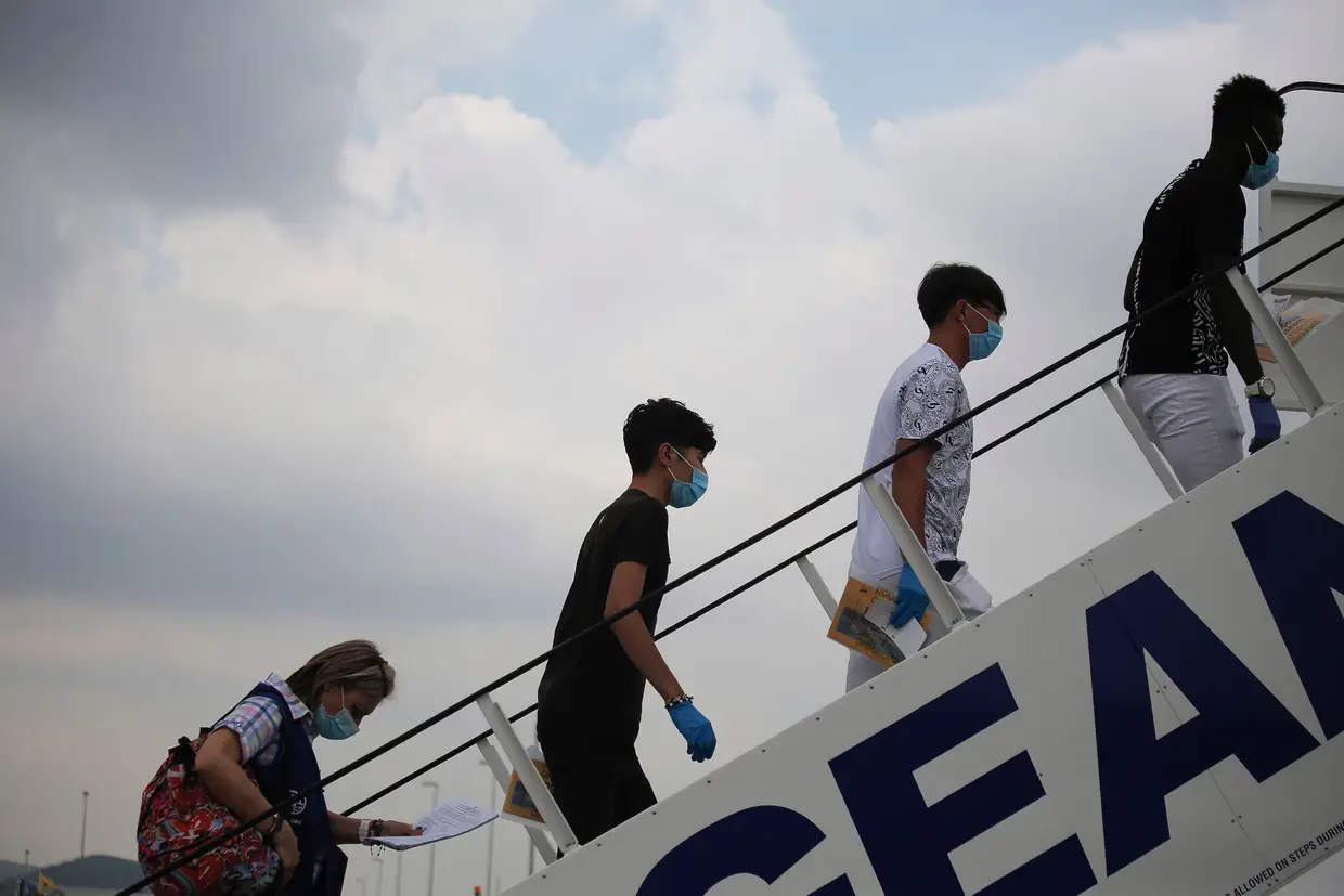Um grupo de jovens migrantes embarca num avião, na Grécia, com destino a Portugal, onde vão ser recebidos ao abrigo do Programa de Recolocação Voluntária.