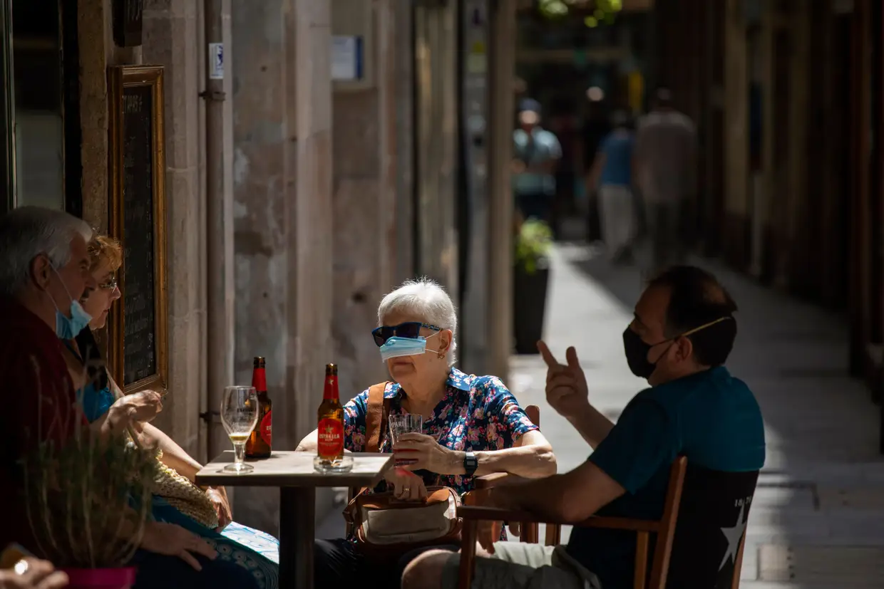 Quatro pessoas numa esplanada em Barcelona, Espanha.