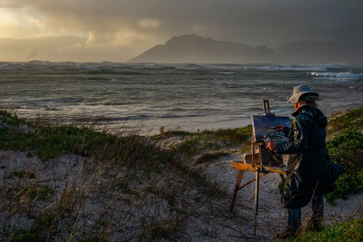 Artista pinta durante uma tempestade na Cidade do Cabo, na África do Sul.