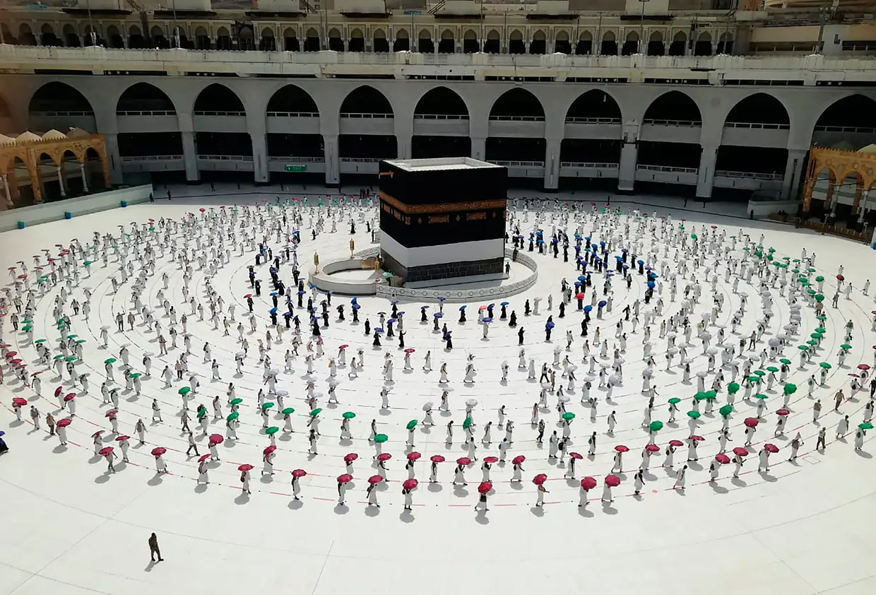 Centenas de peregrinos muçulmanos cumprem o distanciamento social à volta da Caaba, o edifício cúbico da Grande Mesquita, em Meca.