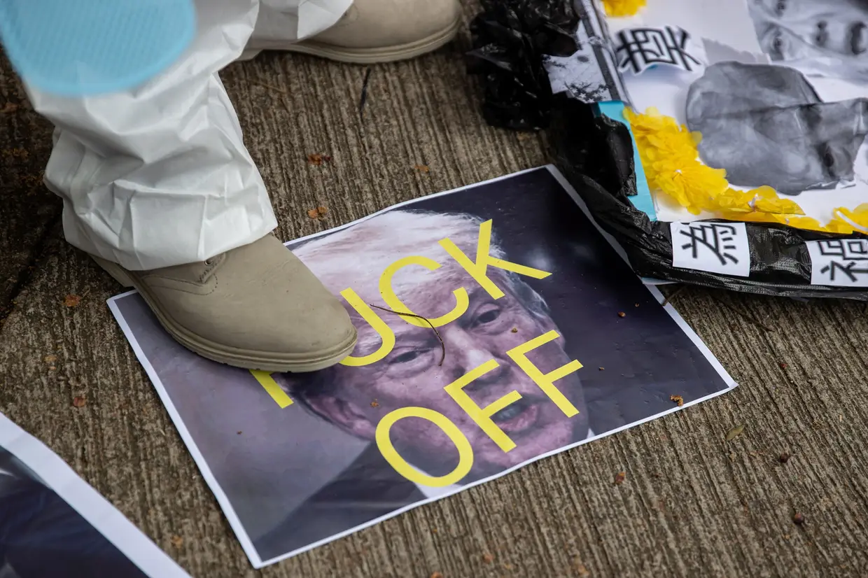 Um ativista pró-China pisa uma fotografia do Presidente dos Estados Unidos, Donald Trump, durante um protesto junto ao consulado norte-americano em Hong Kong.