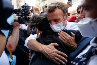 O presidente francês Emmanuel Macron abraça uma moradora ao visitar uma rua devastada de Beirute, Líbano, na quinta-feira, 6 de agosto de 2020.