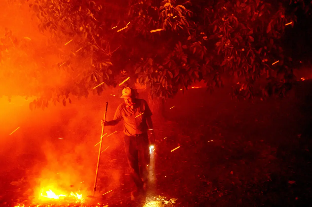 Bill Nichols, de 84ano, tenta salvar a sua casa durante um incêndio Vacaville, na Califórnia. Nichols mora naquela casa há 77 anos.