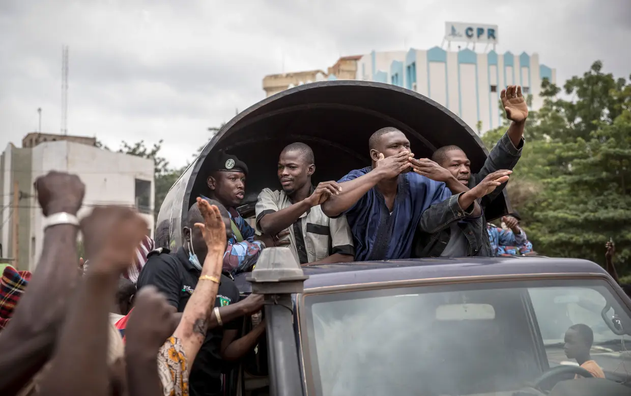 Civis aplaudem a polícia e os militares do Mali que libertaram os presos por desobedicência civil sob o governo de Ibrahim Boubakar Keita, nas ruas de Bamako