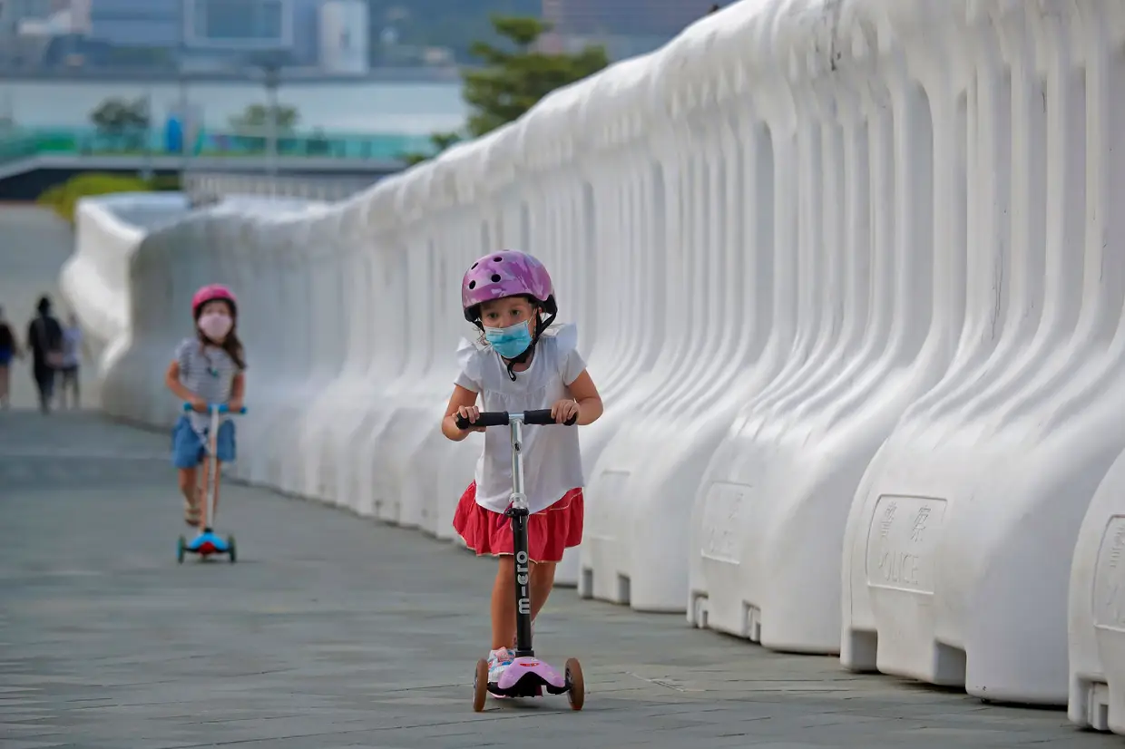 Crianças passeiam num parte de Hong Kong.