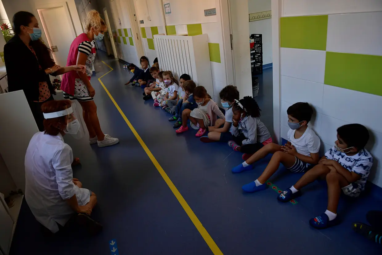 Crianças de máscara recebem instruções especiais sobre a prevenção do coronavírus numa escola em Pamplona, Espanha.