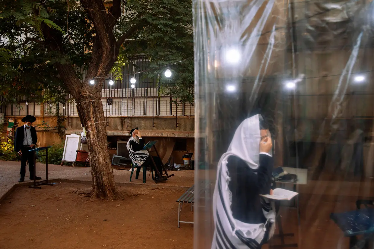 Judeus ultraortodoxos durante uma oração matinal, uma vez que as sinagogas são limitadas a vinte pessoas, em Bnei Brak, Israel.