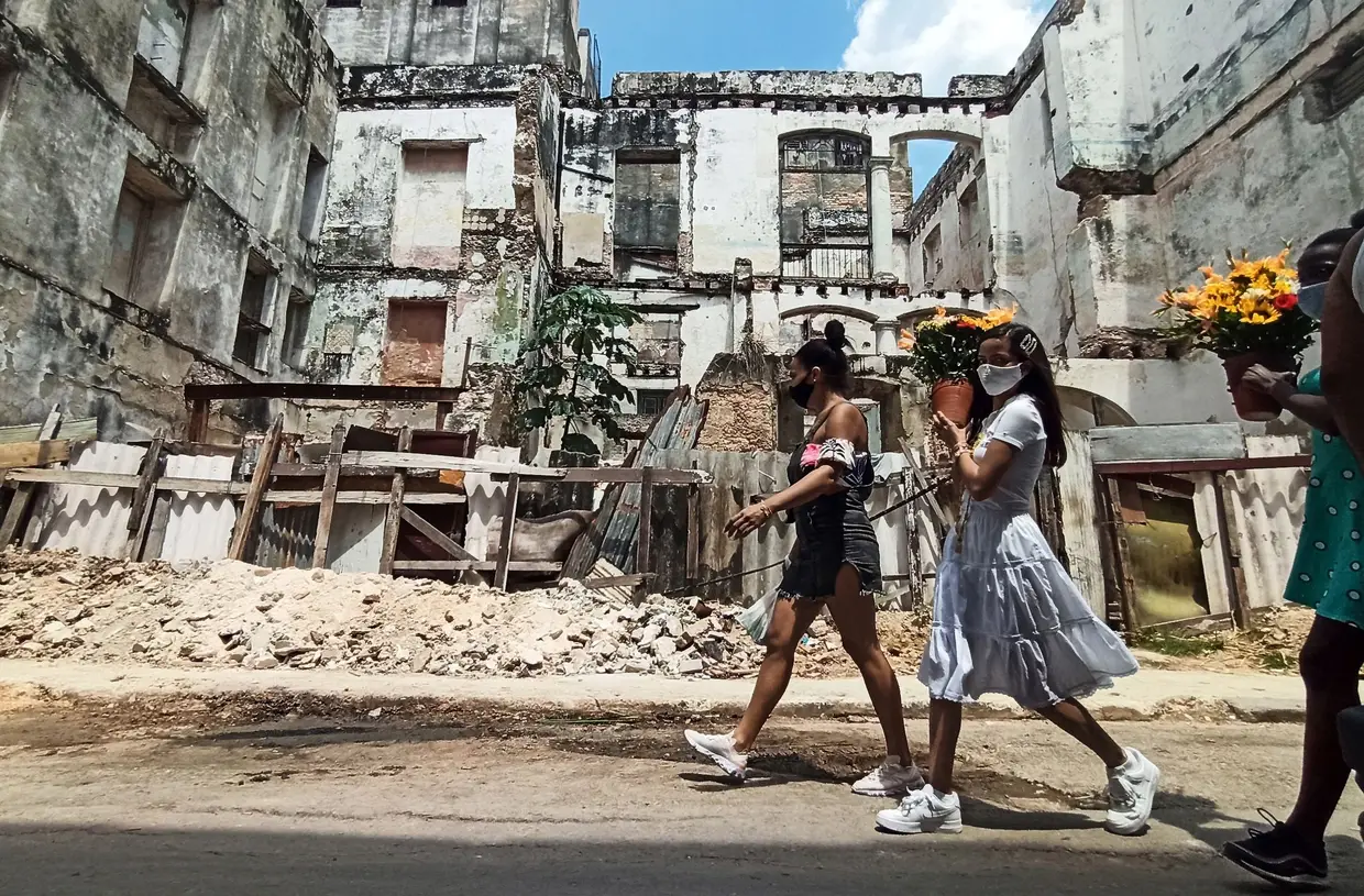 Carregam girassóis para a igreja de Nossa Senhora da Caridade de El Cobre, Havana.