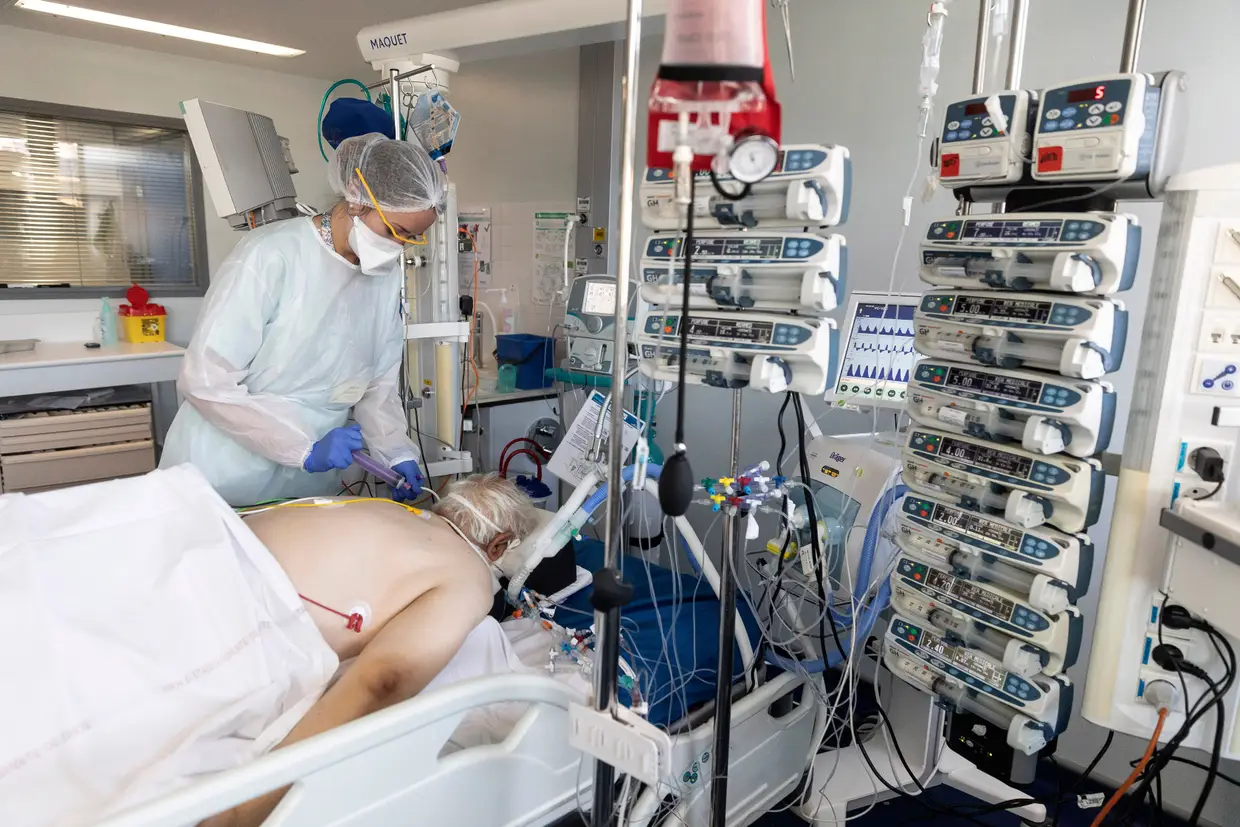 Um profissional de saúde cuida de um paciente infetado com coronavírus internado num hospital em Estrasburgo, França.