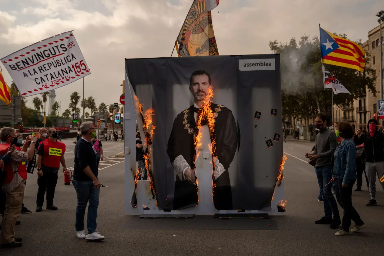 Ativistas do grupo de pró-independência da Catalunha queimam um retrato do rei da Espanha, Felipe VI, durante uma manifestação em Barcelona