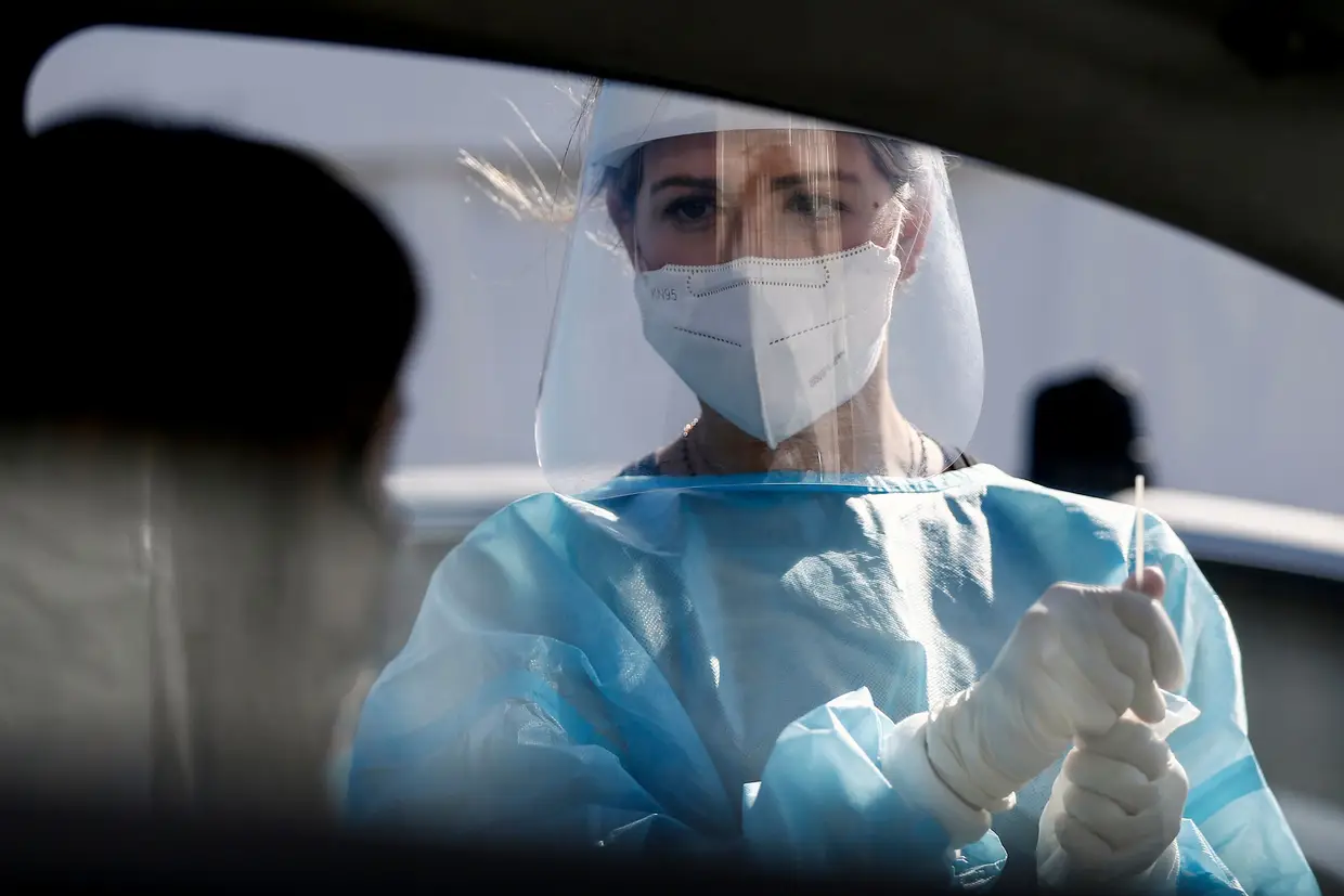 Membro de equipa médica faz um teste à covid-19 no aeroporto Leonardo da Vinci em Roma, Itália