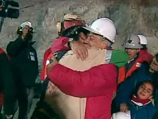 Florencio Ávalos, à esquerda, o primeiro mineiro a ser resgatado, abraça o Presidente do Chile Sebastián Piñera.