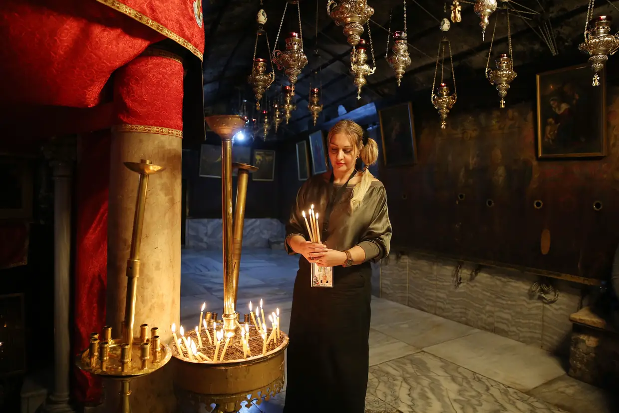 Peregrinos cristãos rezam na Gruta da Natividade, tradicionalmente conhecida por ser o local de nascimento de Jesus Cristo, na cidade de Belém, na Cisjordânia.