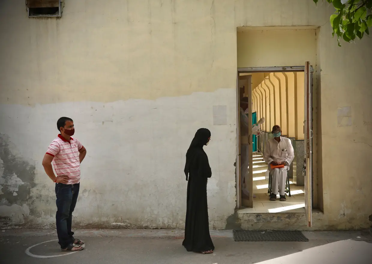 Pessoas na fila, com distanciamento social, para levarem a vacina contra a covid-19, em Nova Deli, Índia.