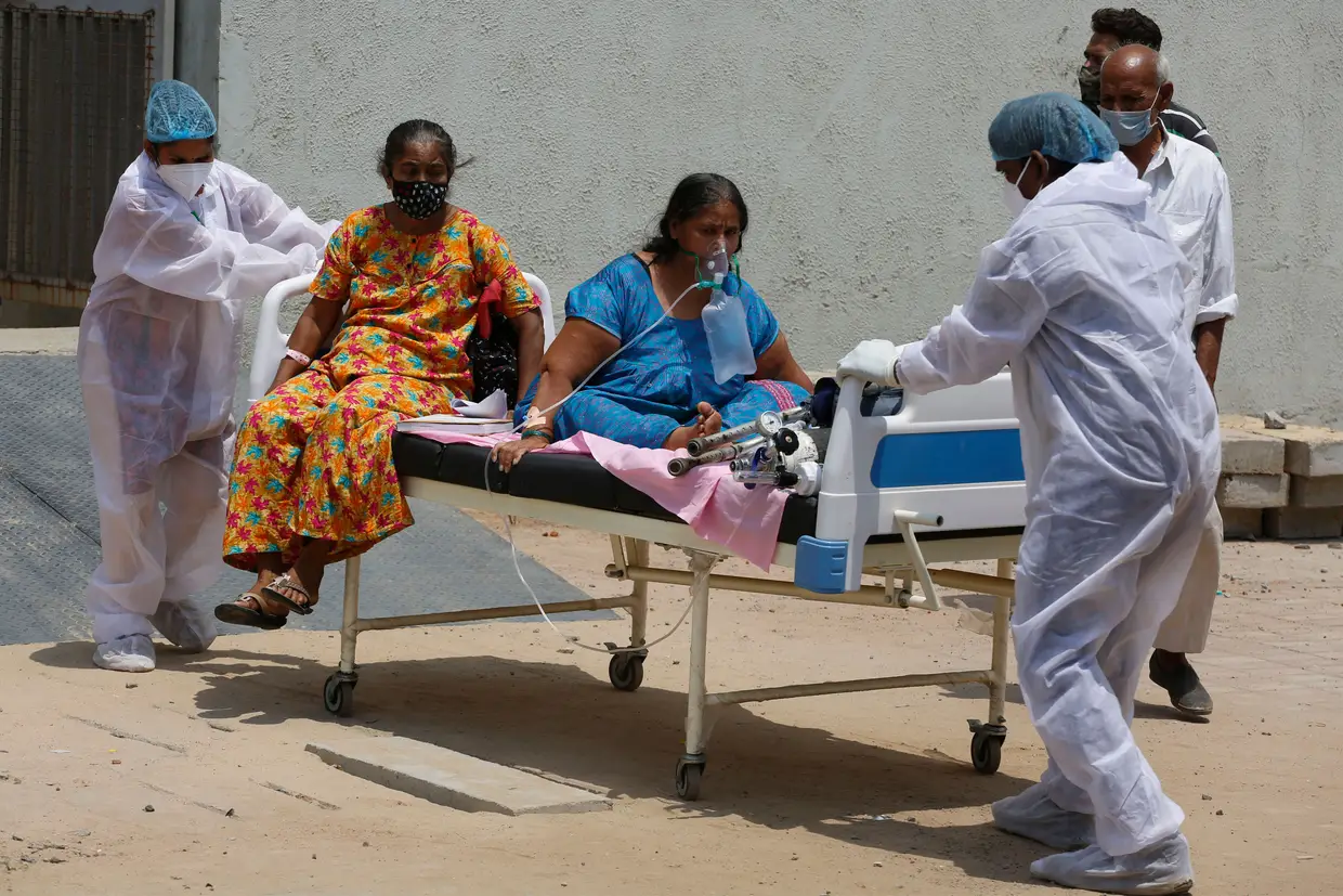 Profissional de saúde trasnporta pacientes de um hospital para outro para desocupar a cama para novos pacientes, no Hospital Civil em Ahmedabad, Índia