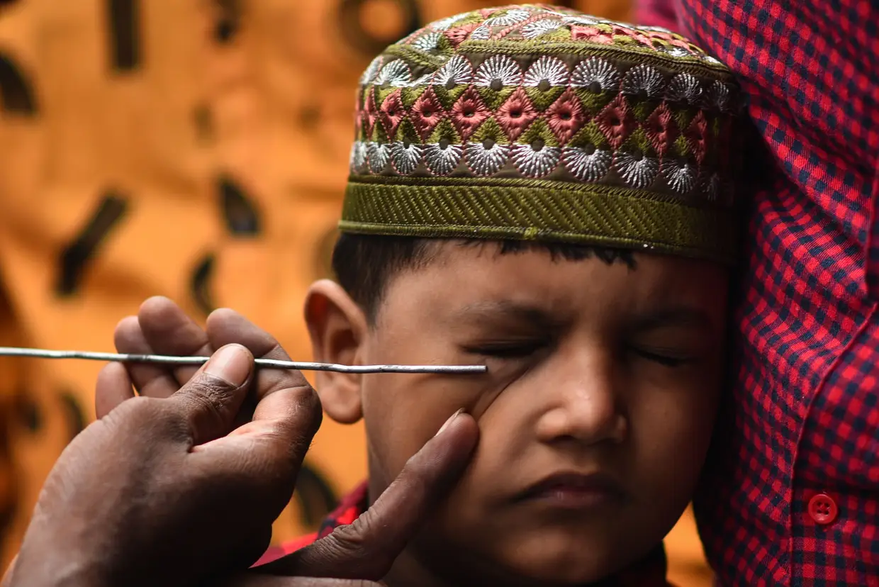 Um menino é pintado nos olhos com o tradicional delineador Kohl, nas celebrações do festival Eid Al-Adha em Chennai, na Índia.