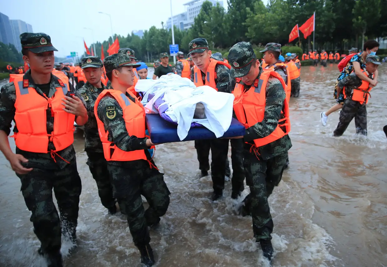 Equipas de resgate evacuam cidadãos de um hospital onde cerca de 3.000 pessoas estavam encurraladas pelas cheias em Zhengzhou, província de Henan, 22 de julho 2021.